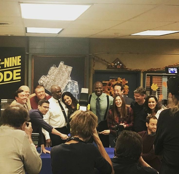 a group of people standing around each other in front of a sign that says the nine nine code