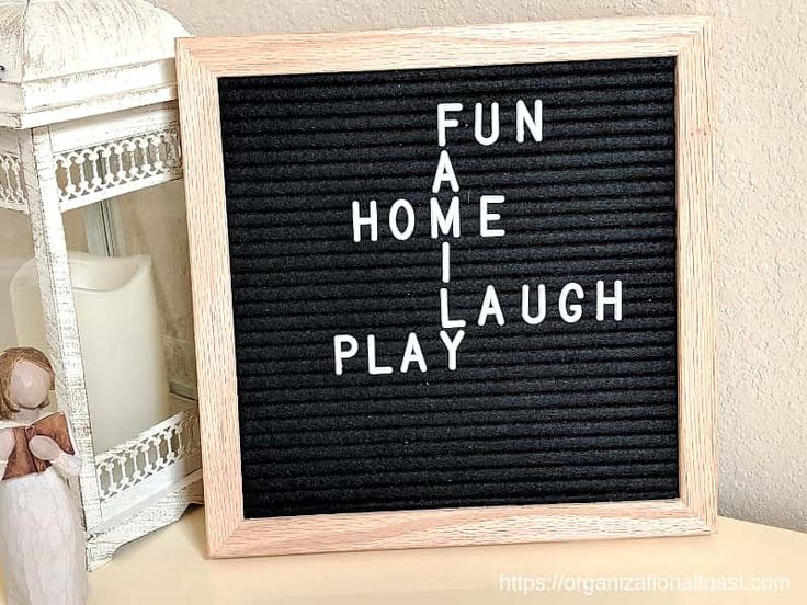 a wooden sign that says fun at home i play laugh on the side of a table