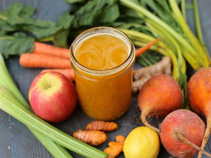 there are many fruits and vegetables next to a jar of honey on the table with carrots