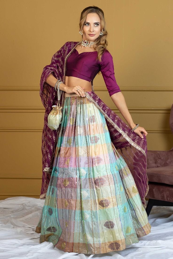 Model: 5'7 - 175 cm and 119 lbs - 54 kg size S Etoile is your go-to ensemble for Bollywood nights, mehndi, and other wedding events. It's an element of grandiose featuring Fuschia silk choli blouse featuring a heart neckline. The kattan silk long skirt in multicolored hue comes with self-woven intricate design. The attire gets complete with a plum colored dupatta beautifully sculpted with four side gold lace work and heavy jaal of zardozi all over. Style this gorgeous dress with Maria Nasir's maharani jewelry set and you'd be all set to lit the dance floor on fire. Top: Color: Fuchsia    Fabric: Khattan Silk Short blouse  Heart shaped neckline ¾ sleeves Tassles dangling on back  Bottom: Color: Multicolored  Fabric: Khattan Silk Lehnga  Cotton silk lining inside Dupatta: Color: Fuchis Fabri Multicolor Bohemian Anarkali Set For Wedding, Multicolor Anarkali Set With Unstitched Blouse For Wedding, Multicolor Bandhani Print Sets For Reception, Multicolor Bandhani Print Sharara For Wedding, Bohemian Multicolor Anarkali Set For Wedding, Purple Bandhani Traditional Wear For Wedding, Multicolor Self-design Lehenga For Reception, Multicolor Bandhani Print Lehenga For Reception, Multicolor Bandhani Print Choli For Weddings