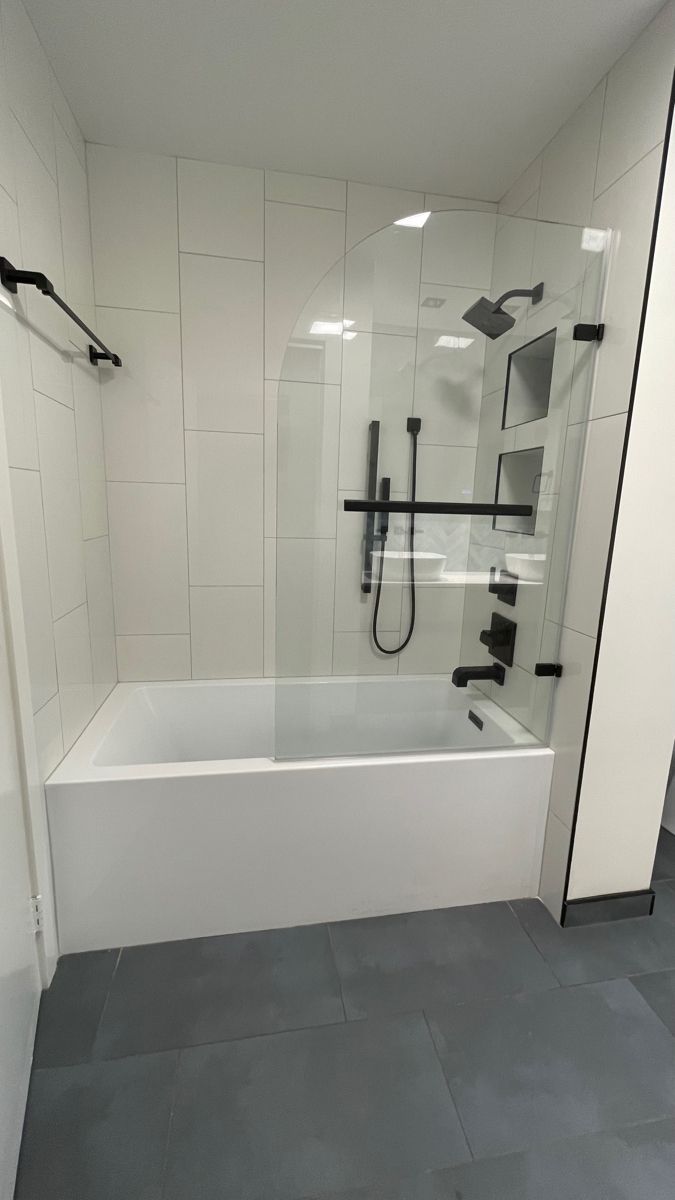 a white bath tub sitting next to a walk in shower