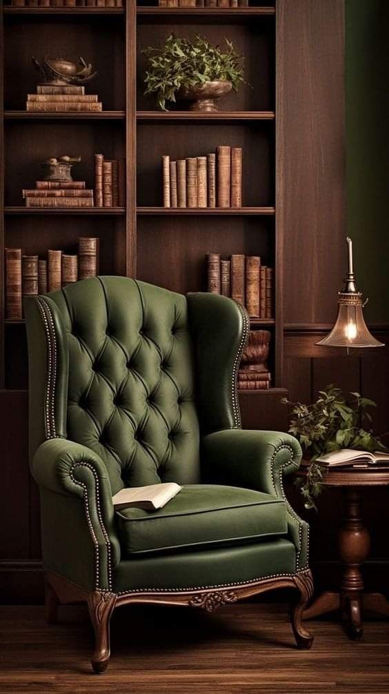 a green chair sitting in front of a book shelf filled with books