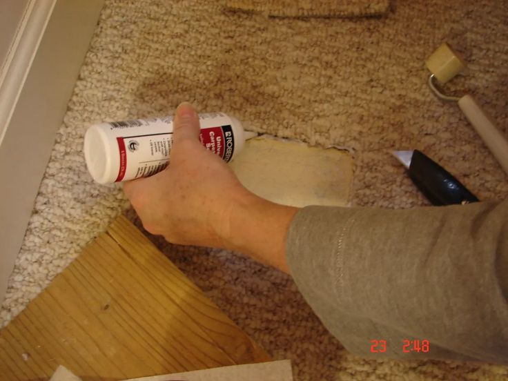 a person using a paint roller on the floor