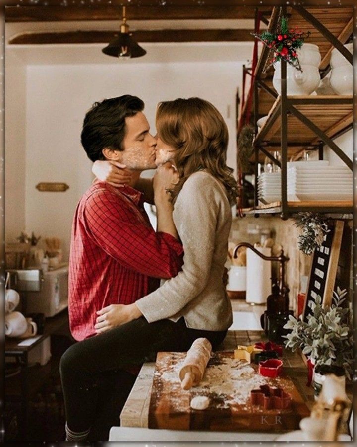 a man and woman kissing in the kitchen