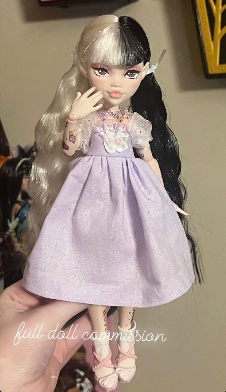 a close up of a doll wearing a dress and holding her hand near her face