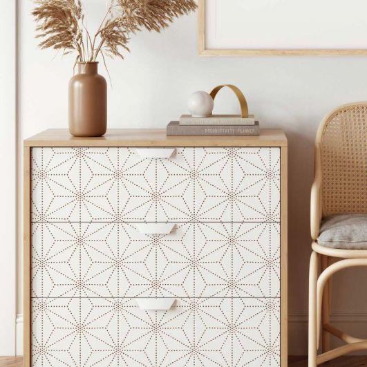 a white and brown cabinet with a vase on top of it next to a chair