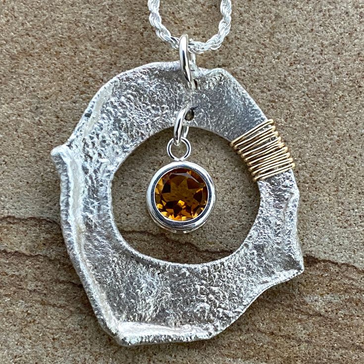 The flair of 14-karat gold fill accents adds a shimmer to the handcrafted Citrine Pendulum. This reticulated silver work of art hangs from a sterling chain and showcases a round citrine stone within a smooth, sleek housing. Energize your aura with the warming influence of citrine, balanced with the cool precision of artisan-crafted silver jewelry. 8mm round citrine (about 1.8 tcw) 1.25"x1.5" reticulated sterling pendulum 14k gold fill accents adjustable (16"-24") sterling rope chain includes adj Modern Topaz Birthstone Jewelry, Modern Citrine Gemstone Jewelry, Modern Citrine Jewelry With Polished Finish, Modern Citrine Jewelry Gift, Modern Citrine Jewelry For Gift, Modern Amber Jewelry With Citrine, Modern Amber Citrine Jewelry, Citrine Birthstone Round Pendant Jewelry, Citrine Birthstone Round Pendant