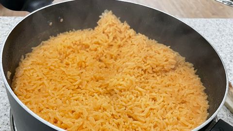 a pan filled with rice sitting on top of a stove