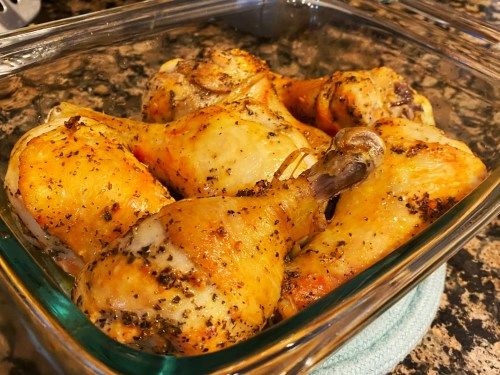 a glass dish filled with cooked chicken on top of a counter