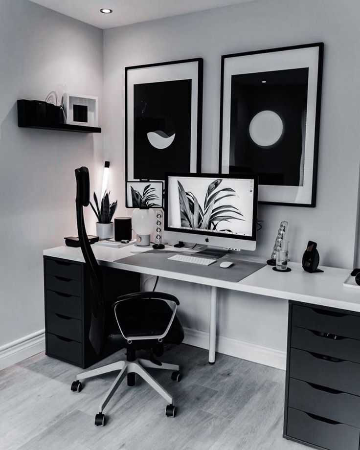 a desk with two computer monitors and a black chair