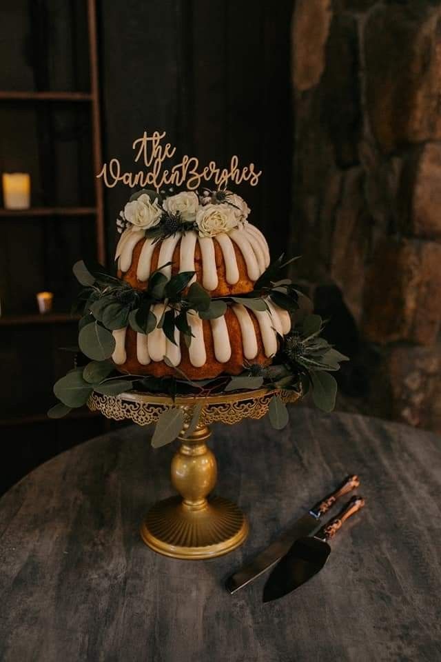 there is a cake that has been decorated with flowers and leaves on the top tier