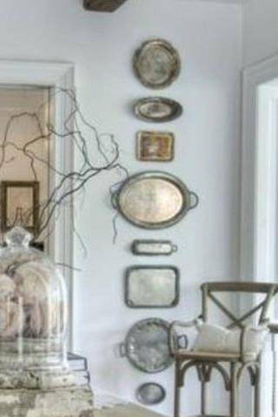 a room with several plates on the wall and a table in front of it that has a glass clochet