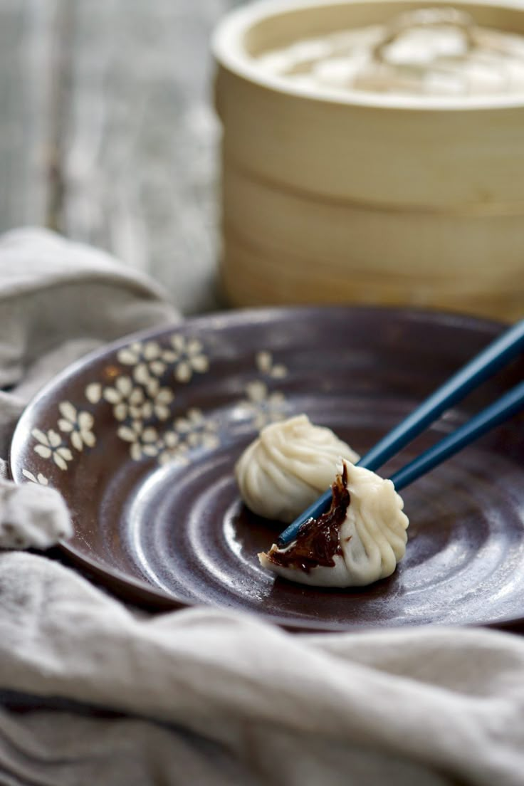 two chopsticks on a plate with some food