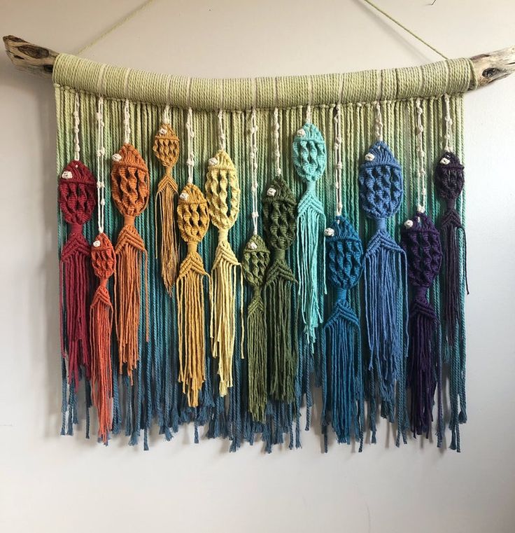 there are many different colors of yarn hanging on the wall