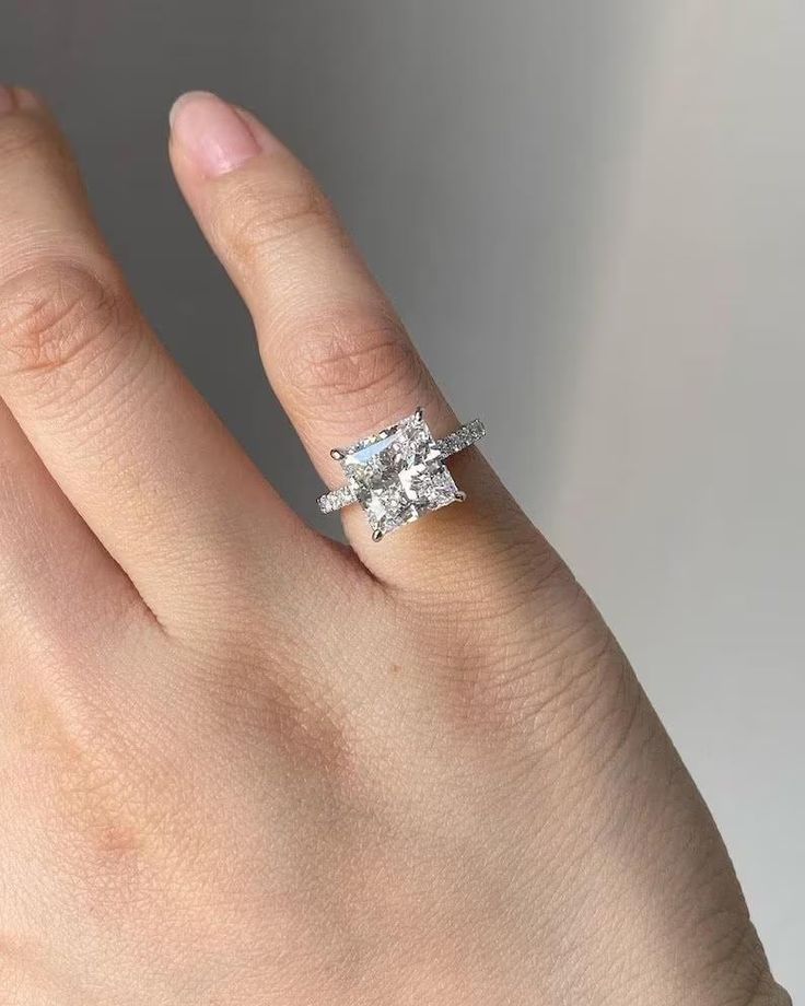 a woman's hand with an engagement ring on it