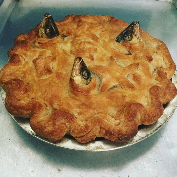 a pie with fish on it sitting in a pan