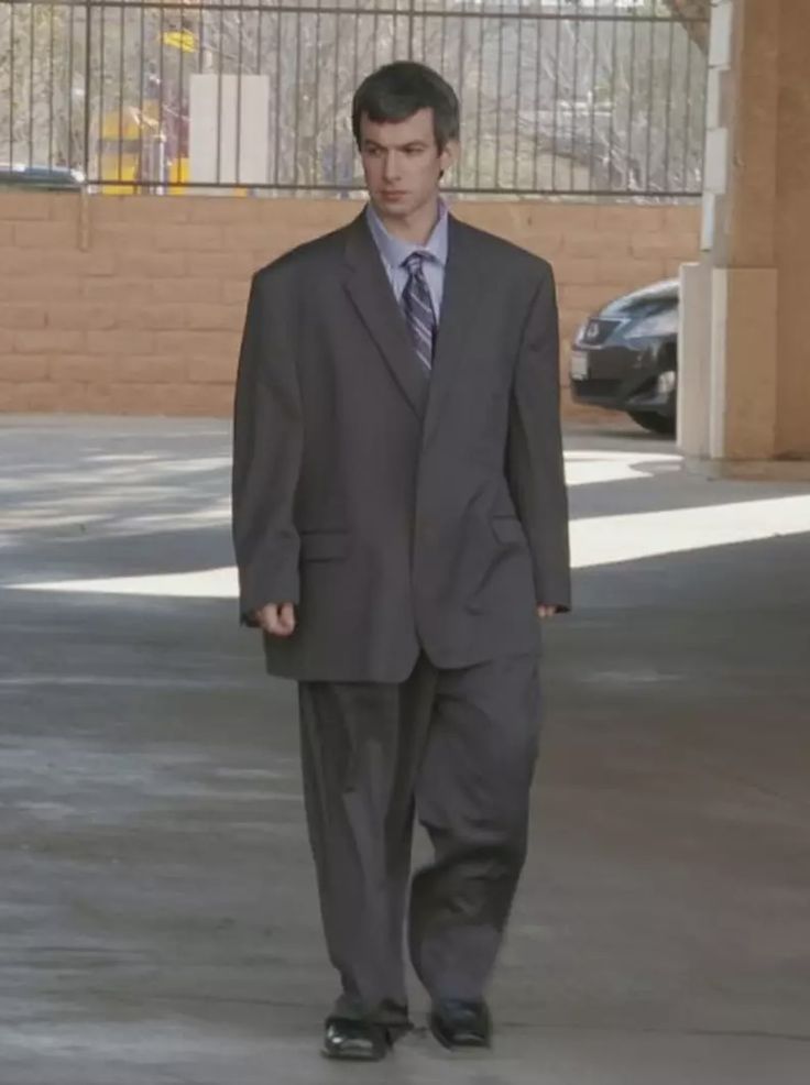 a man in a suit and tie walking down the street