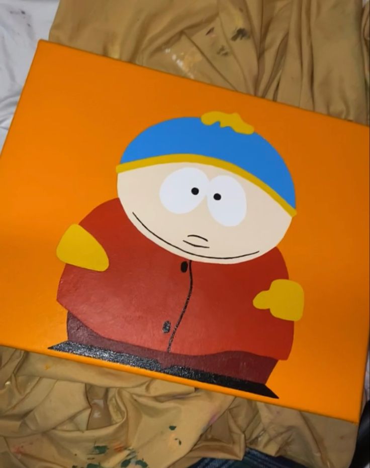 an orange box with a painting of a man wearing a blue beanie on it