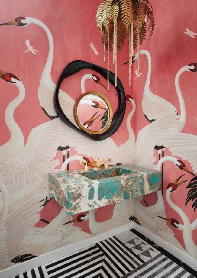 a bathroom with flamingos painted on the wall and a sink in front of it