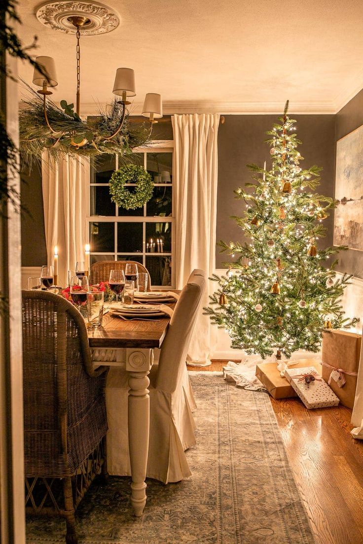 a dining room with a christmas tree in the corner and other decorations on the table