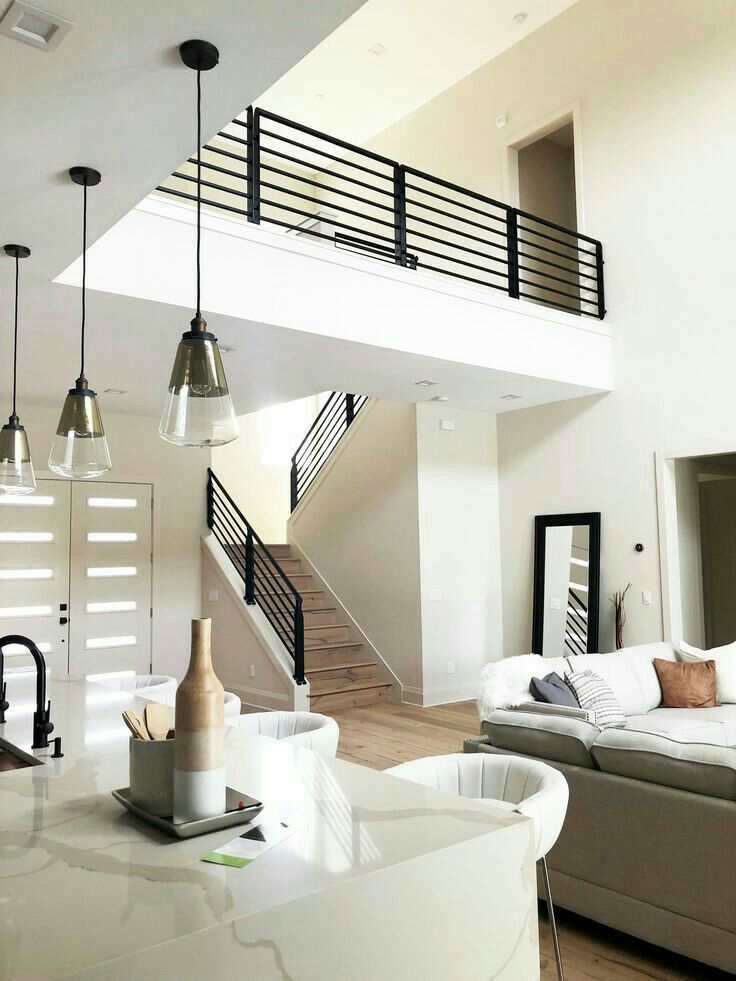 a living room filled with furniture next to a staircase