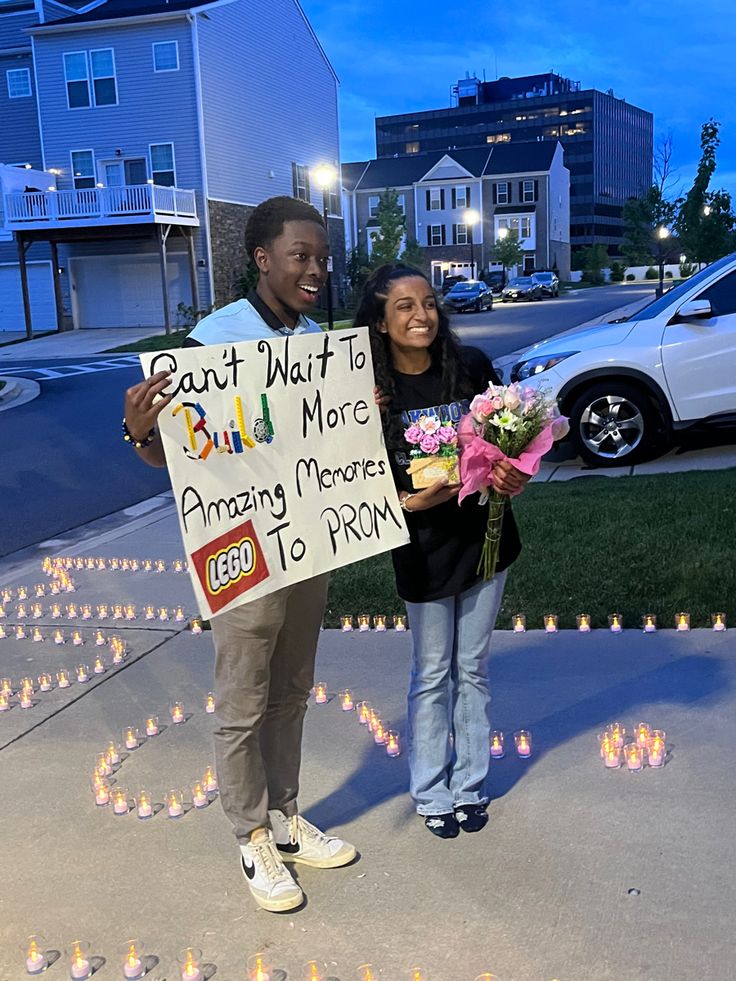 two people holding flowers and a sign that says eat plant to be more amazing memories to prom