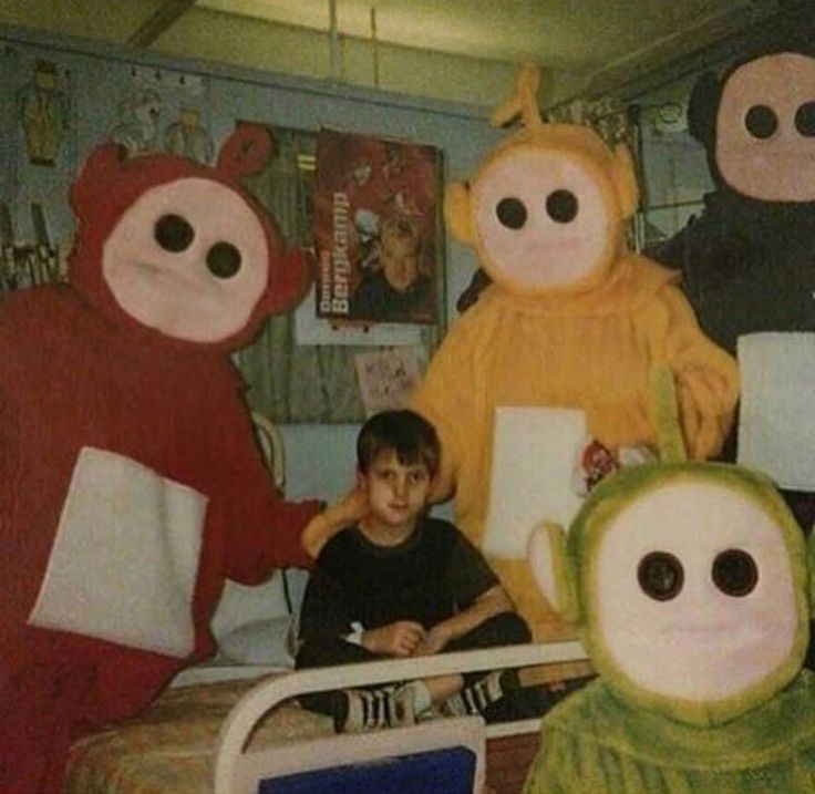 there are many stuffed animals sitting on the bed with two boys and one is writing