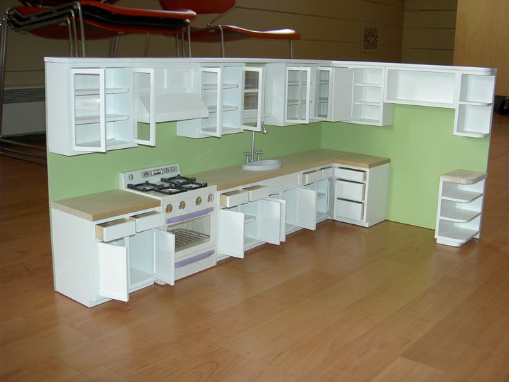 a model kitchen is shown with white cabinets and drawers on the counter top, as well as an oven