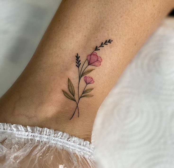 a small flower tattoo on the ankle