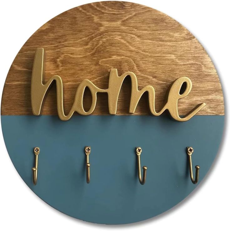 a wooden sign that says home with hooks on the front and back of it in gold