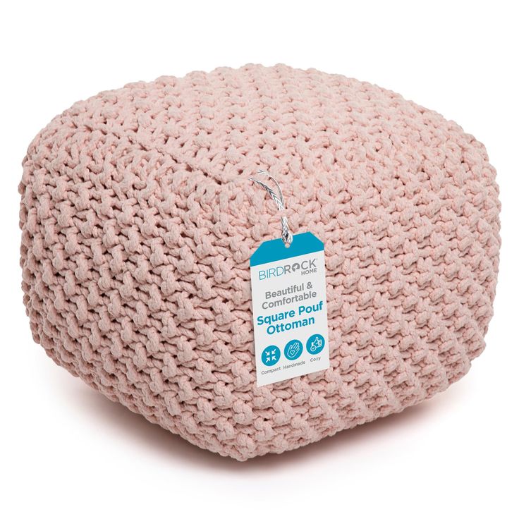 a pink knitted cushion with a tag on it