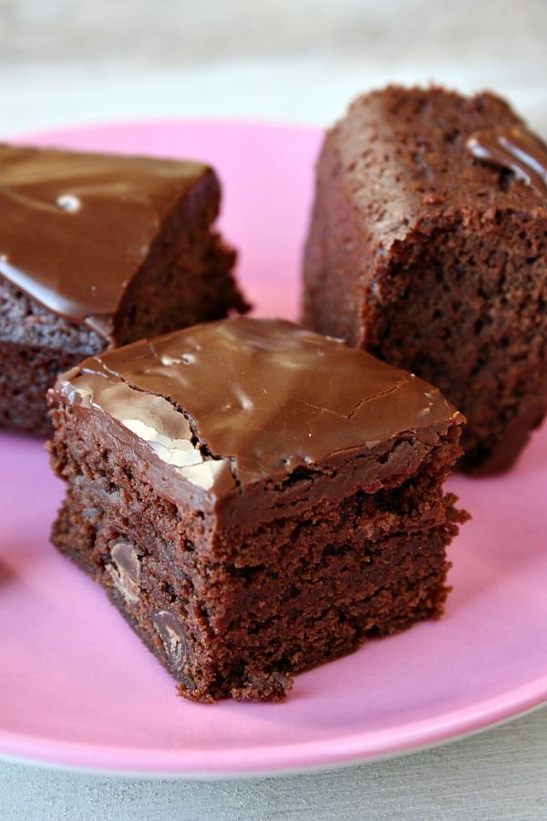 three pieces of chocolate cake on a pink plate