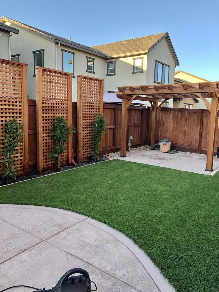 a backyard with artificial grass and wooden fence