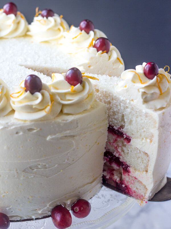 a cake with white frosting and cherries on top