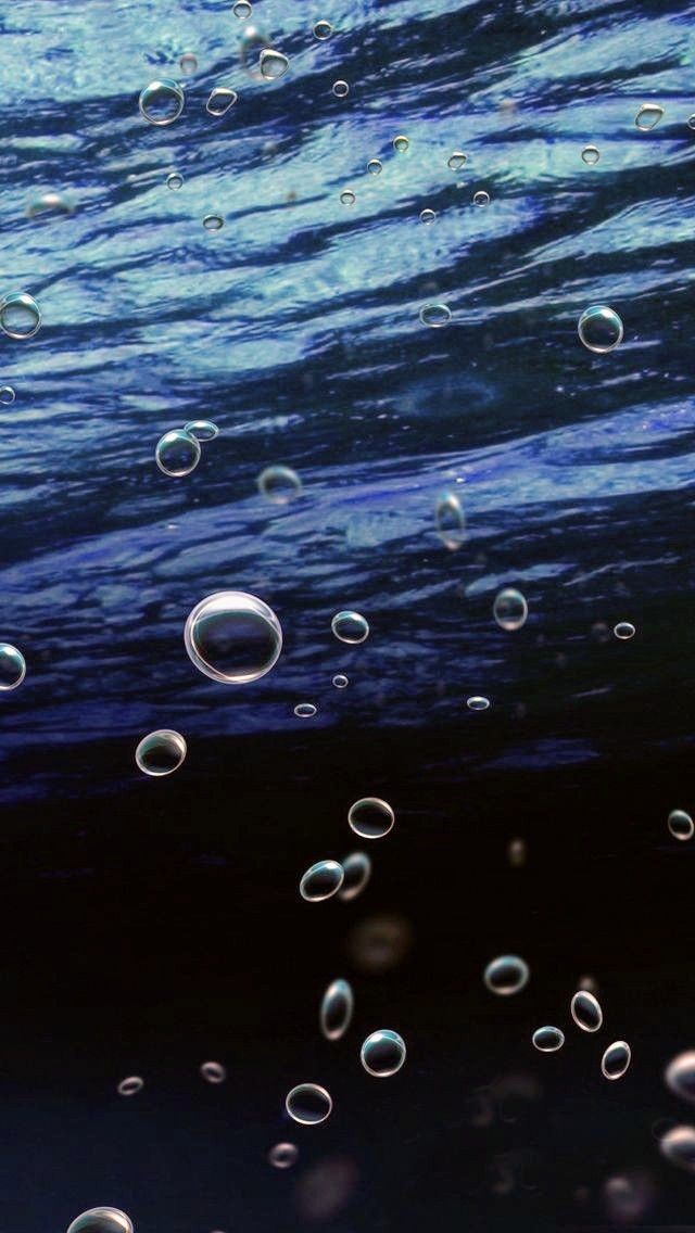 bubbles are floating in the blue water