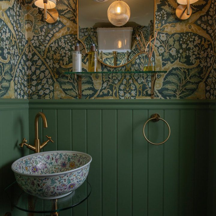 a bathroom with green walls and a sink in the corner, surrounded by hanging lights