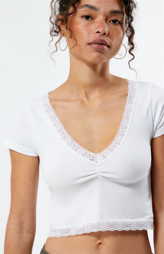 Introducing the Genevieve Seamless Lace Top from Contour, the ultimate blend of comfort and style. Designed with seamless ribbed fabric, this crop top is complete with short sleeves, a v-neckline, lace trimming, and cinched front detail. 


	Seamless ribbed fabric
	Short sleeves
	V-neckline
	Lace trim
	Cinched front detail
	Cropped length
	Fitted
	94% polyester, 6% elastane
	Machine washable
	Model is wearing a size small Womens Lace Tops, Shop Makeup, Jersey Top, Ribbed Fabric, Pacsun, Summer Style, Lace Trim, Lace Top, Summer Fashion