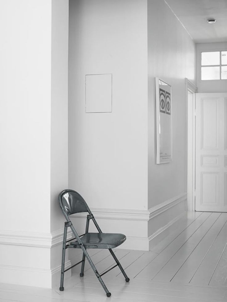 a black and white photo of a chair in a hallway