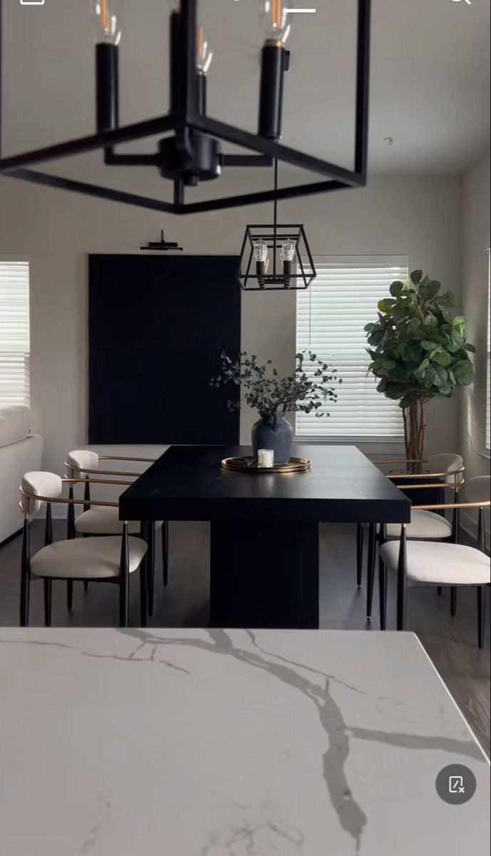 a black and white dining room table surrounded by chairs