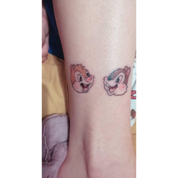 two small tattoos on the foot of someone's feet, one with an animal and another with a squirrel