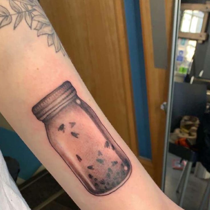 a person with a jar tattoo on their arm