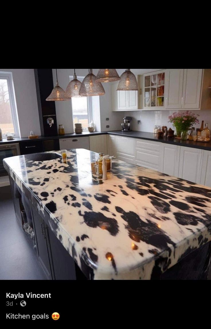 a kitchen with an island made out of cow hides and lights hanging from the ceiling