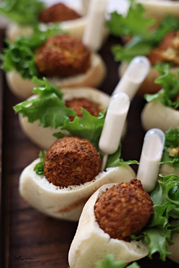 small appetizers with meatballs, lettuce and sauces on them