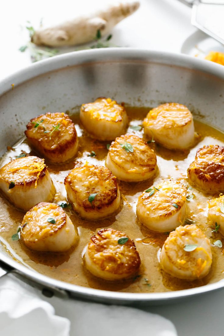 some scallops are cooking in a pan on the table