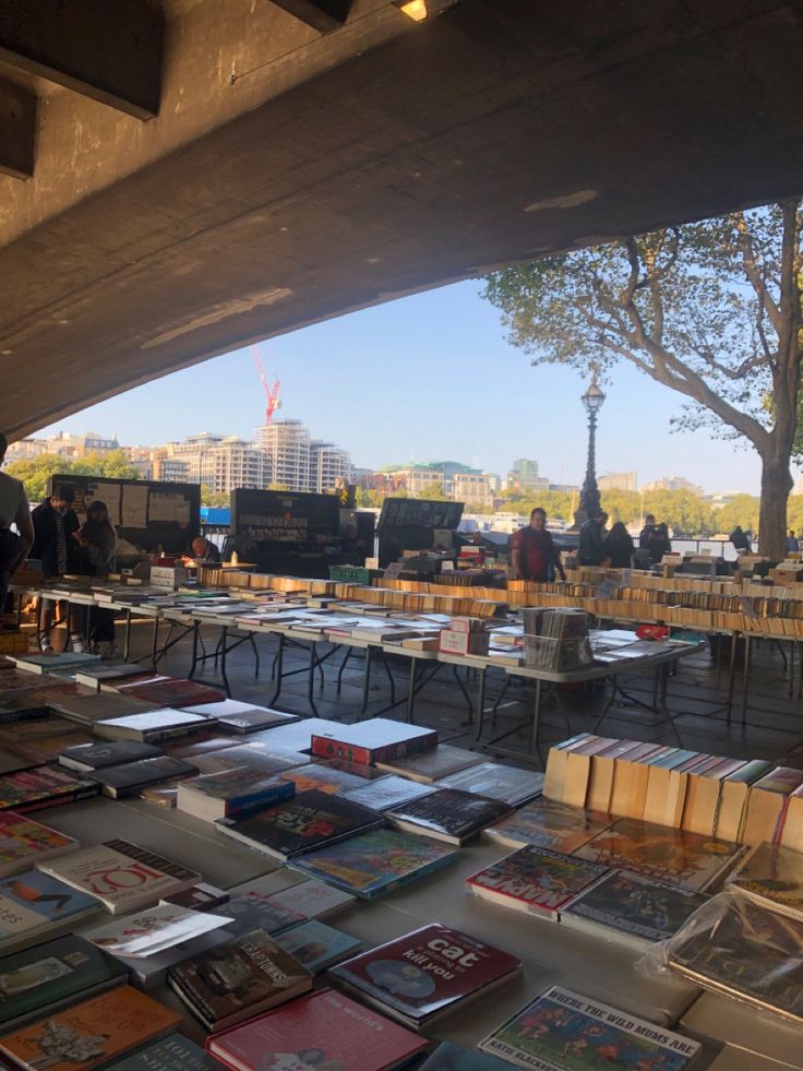 many books are on tables under an overpass