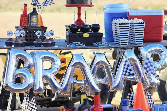 a table topped with balloons and letters that spell out the word brava on it