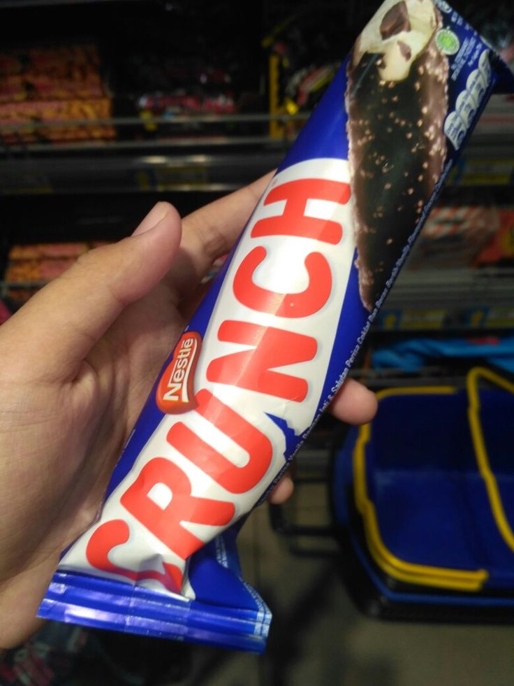 a hand holding a bar of crunch candy