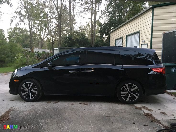 a black minivan parked in front of a garage