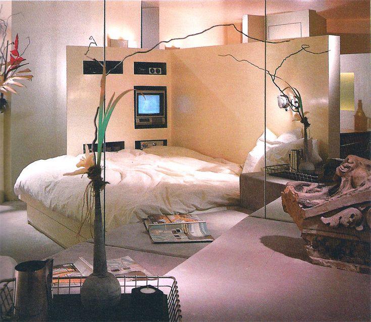 a bed room with a neatly made bed and mirror walls