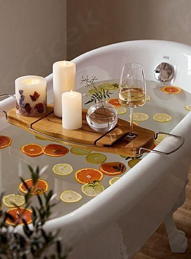 a bath tub filled with candles and orange slices on top of it's tray